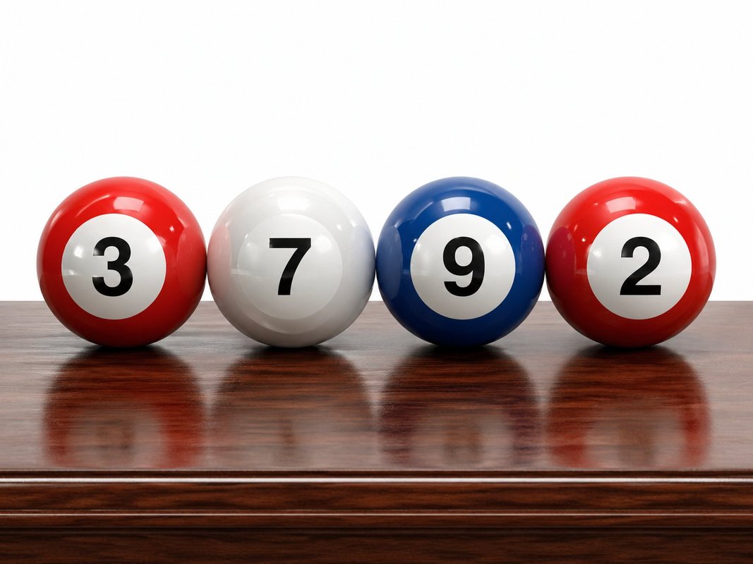 Four lottery balls in Texas flag colors showing the numbers 3, 7, 9, 2